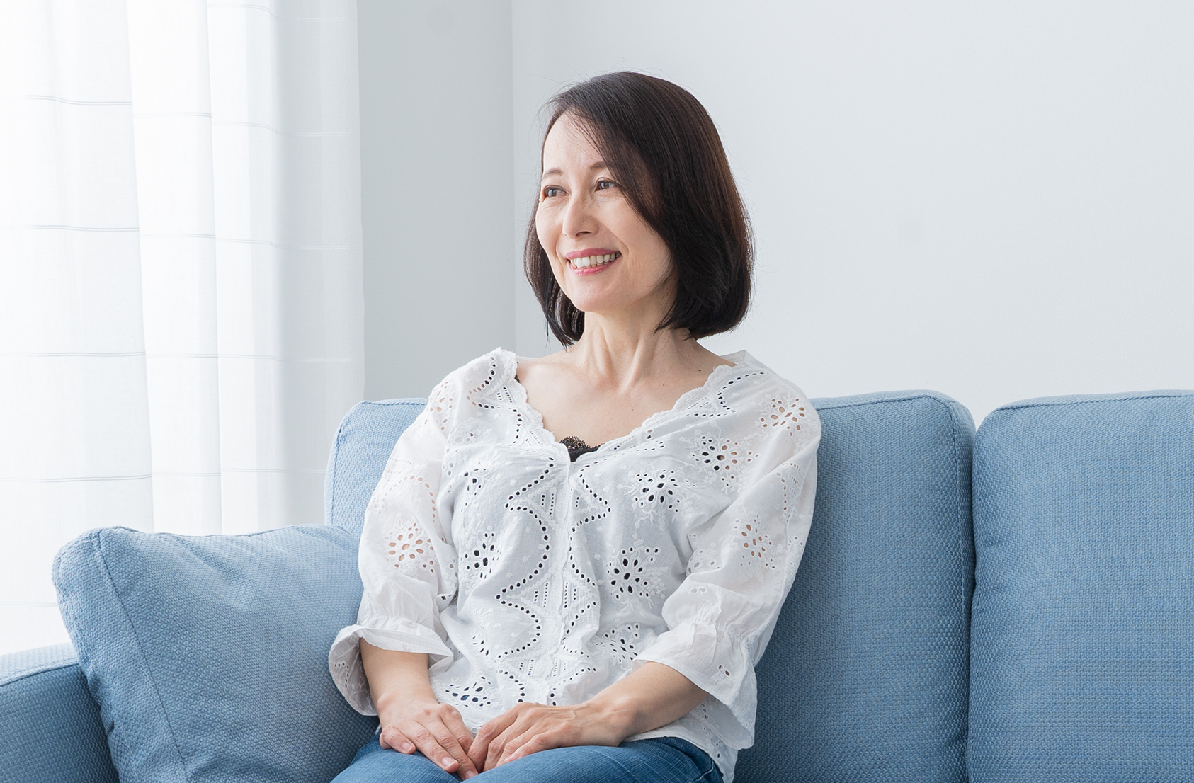窓を見つめる乳がん経験者のエリコさん